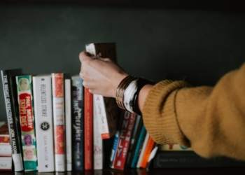 Pessoa organizando uma prateleira de livros